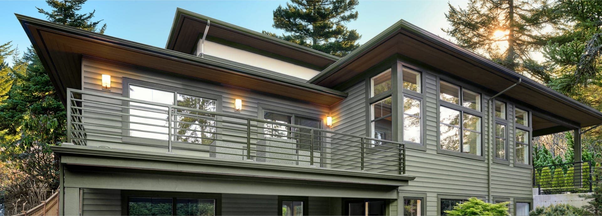 Contemporary house exterior with balcony and outdoor lighting.
